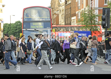 Pedoni che attraversano la strada di fronte bus Angel Islington Londra Inghilterra REGNO UNITO Foto Stock