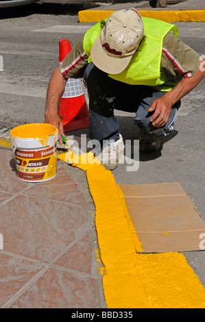 Pittura a mano cordolo giallo Foto Stock