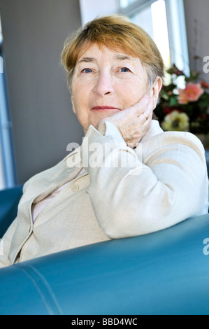 Donna anziana seduta in bianco lino camicia Foto Stock