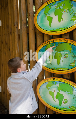 Un giovane ragazzo puntando in Inghilterra su una mappa presso lo Zoo di Edimburgo, Scozia, Regno Unito Foto Stock