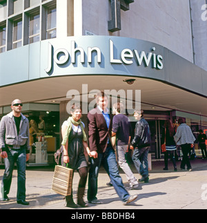 Gli amanti dello shopping con sacchetti di passato a piedi l'ingresso al John Lewis department store in Oxford Street Londra Inghilterra REGNO UNITO Foto Stock