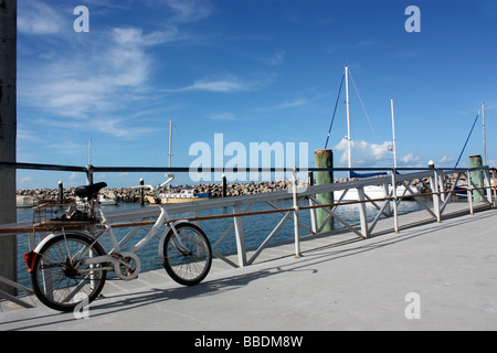 Vecchio PUSHBIKE parcheggiato su un molo cielo blu di sfondo BDA ORIZZONTALE Foto Stock