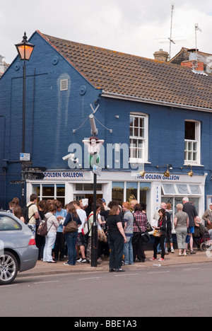 I clienti queing fino in un lungo que al di fuori del galeone Golden Fish & Chip shop nella città costiera di Aldeburgh,Suffolk, Regno Unito Foto Stock