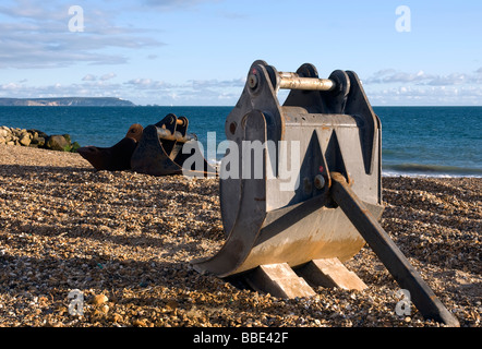 Il movimento terra pale sparse su tutta la spiaggia di Barton on Sea, England, Regno Unito Foto Stock