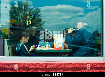 Nonno e nipote pranzo presso un ristorante fast food Foto Stock