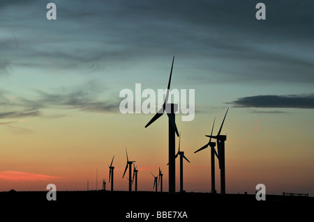Una linea di dieci turbine a vento stagliano contro il cielo magico di un tramonto rosso, Ovenden Moor, a nord di Halifax, Regno Unito Foto Stock