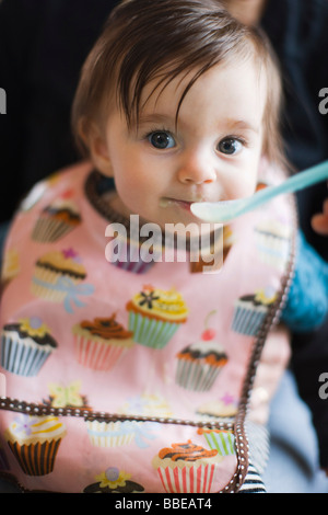 Baby girl degustazione cibi solidi per la prima volta Foto Stock