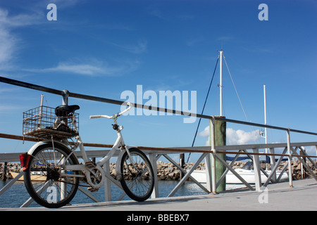 Vecchio PUSHBIKE parcheggiato su un molo cielo blu di sfondo BDA ORIZZONTALE Foto Stock