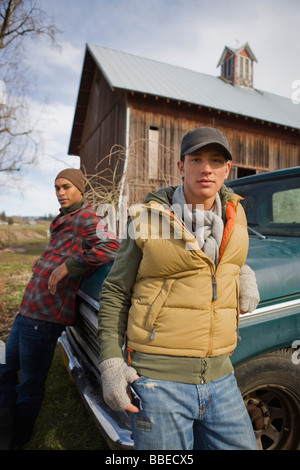 Due giovani uomini da un vecchio camioncino in una fattoria a Hillsboro, Oregon, Stati Uniti d'America Foto Stock