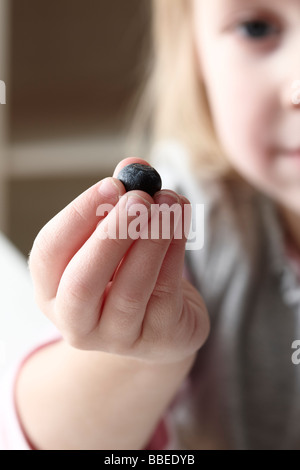 Little Girl Holding mirtillo Foto Stock