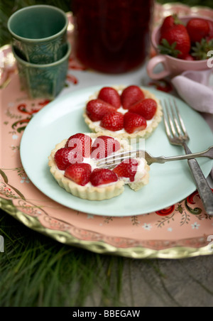 Tartellette alle fragole e tè freddo Foto Stock