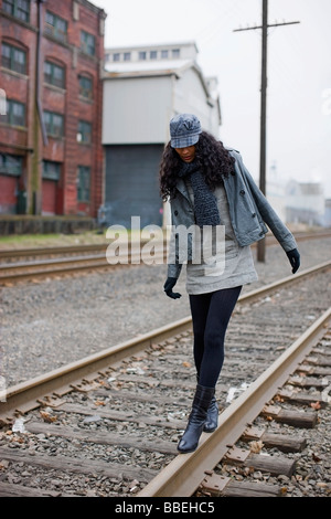 Donna che cammina sui binari della ferrovia urbana di Area Industriale di Portland, Oregon, Stati Uniti d'America Foto Stock