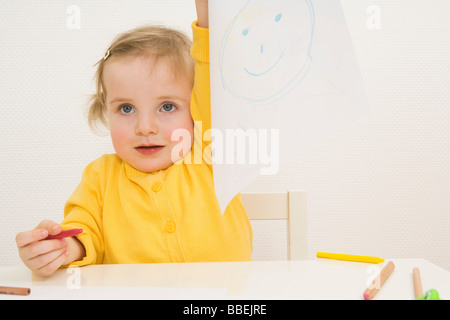 Bambina tenendo in mano il suo disegno Foto Stock