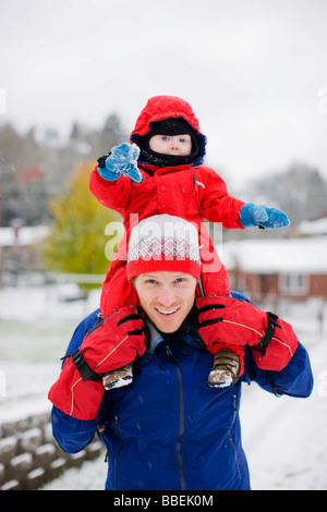 Little Boy a cavallo sul padre di spalle in inverno, Portland, Oregon, Stati Uniti d'America Foto Stock