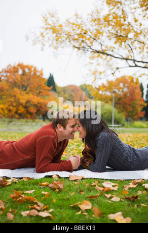 Coppia giacendo su una coperta in un parco in autunno, Portland, Oregon, Stati Uniti d'America Foto Stock