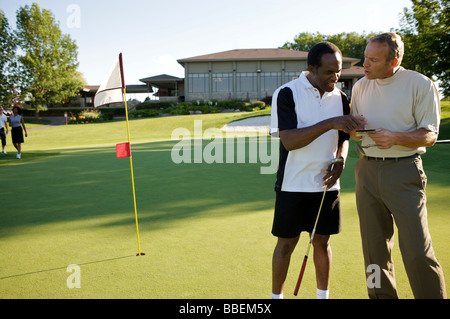 I golfisti guardando score card, Burlington, Ontario, Canada Foto Stock