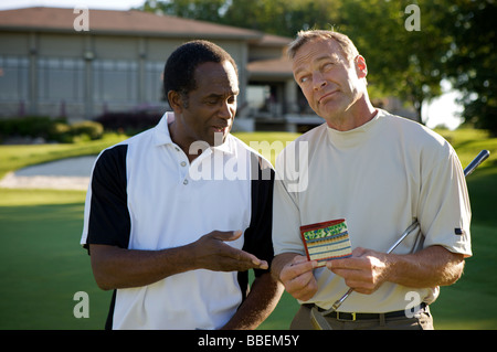 I golfisti guardando score card, Burlington, Ontario, Canada Foto Stock