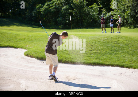 Backview dell uomo nella trappola di sabbia sul campo da Golf Foto Stock