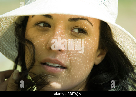 Bruna giovane donna che indossa cappello, close-up Foto Stock