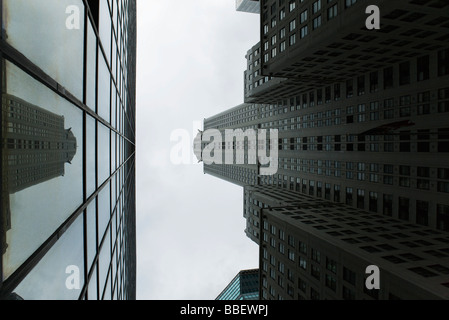 La riflessione del grattacielo di vetro sulla facciata di edificio sul lato opposto della strada, visto dal di sotto Foto Stock