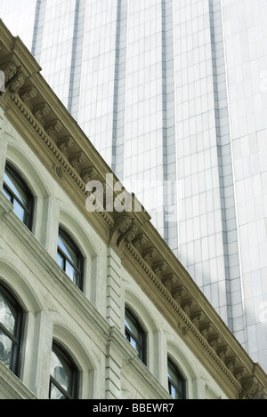 Facciata di edificio neoclassico, e moderno grattacielo svettante al di sopra e a basso angolo di visione Foto Stock