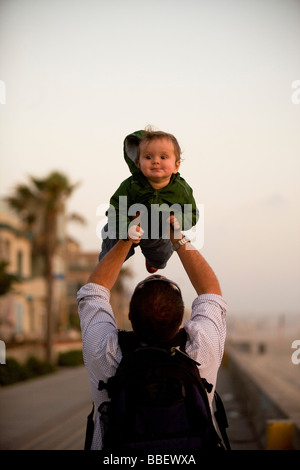Padre e figlio giocare mentre si cammina lungo un fronte mare Foto Stock