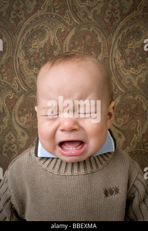 Ritratto di un bambino piangere davanti a un background modellato Foto Stock