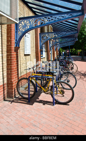 Le biciclette parcheggiate fuori una stazione ferroviaria. Foto Stock