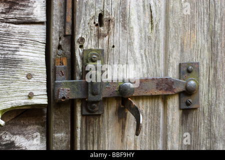 Il dispositivo di chiusura e bloccaggio sul vecchio capannone porta. Foto Stock