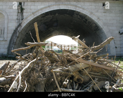 Pila di vecchi rami sotto il ponte dopo l'alluvione Foto Stock