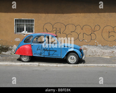 Una Citroen 2CV coperto di graffiti in strada in città città Foto Stock