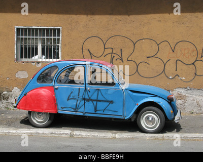 Una Citroen 2CV coperto di graffiti in strada in città città Foto Stock