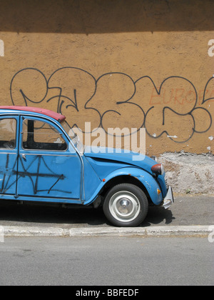 Una Citroen 2CV coperto di graffiti in strada in città città Foto Stock