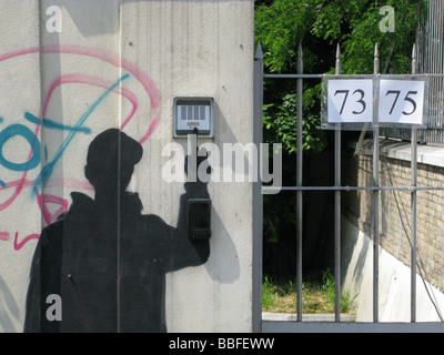 Persona scuro graffiti di campanello squilla su proprietà in strada Foto Stock