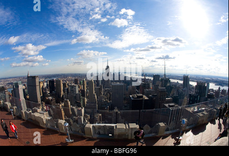 La donna gode di vista dalla sommità della roccia Rockfeller Building guardando sopra manhattan per Empire State Building di New York City NYC Foto Stock