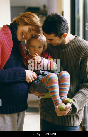 I genitori azienda piccola ragazza sorridente Foto Stock