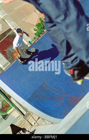 Guidatore di skateboard pattinaggio su lato della rampa, ad alto angolo di visione Foto Stock