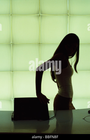 Silhouette di donna la chiusura di computer portatile Foto Stock