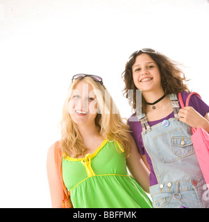 Sorridente due bambine di andare a fare shopping con le borse della spesa Foto Stock