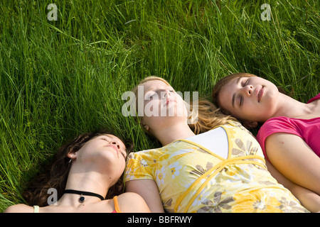 Le tre ragazze dormono in erba Foto Stock