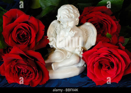 Angelo in ceramica figurine con rose rosse Foto Stock