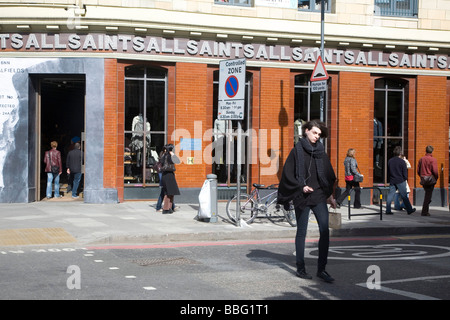 Un ragazzo wallking al di fuori dell'Ognissanti negozio di abbigliamento, Londra UK 2009 Foto Stock