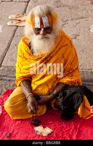 Sadhu o indù uomo santo per l'accattonaggio denaro in Varanasi India Foto Stock