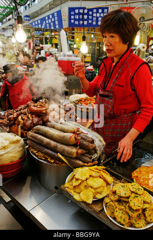 Cibo coreano, donna cucinare in un piccolo ristorante, il cibo in stallo in un mercato a Seul, Corea del Sud, Asia Foto Stock