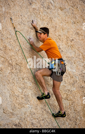 Scalatore risale una ripida roccia sbalzo. Foto Stock