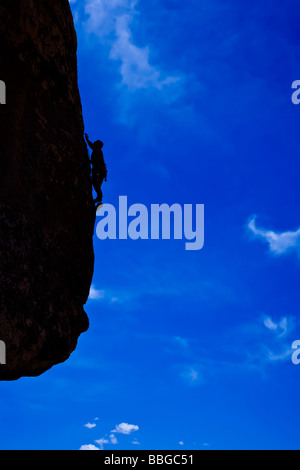 Scalatore risale una ripida roccia sbalzo. Foto Stock