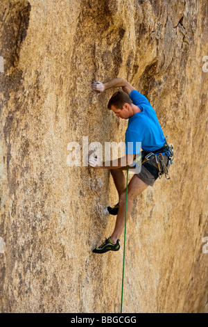 Scalatore risale una ripida roccia sbalzo. Foto Stock