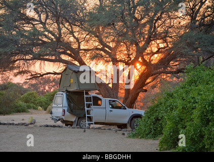 Veicolo fuoristrada con un rooftent, tramonto nel campo del 'White Lady Lodge' a monte Brandberg, Namibia, Africa Foto Stock