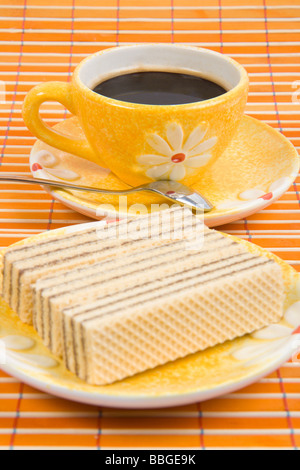 Close up waffle slice e la tazza con il caffè sul bambù panno della tabella Foto Stock