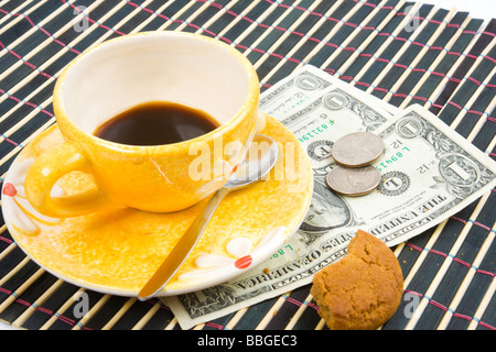 Tre dollari e 50 cent pagare per caffè e biscotti sul bambù panno della tabella Foto Stock